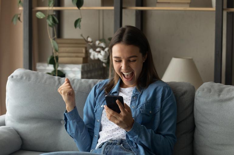 Mujer feliz mirando un celular